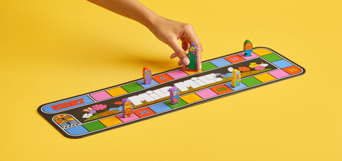 the full game board lay out featuring a start, finish and tiles in between with wooden pieces representing  characters