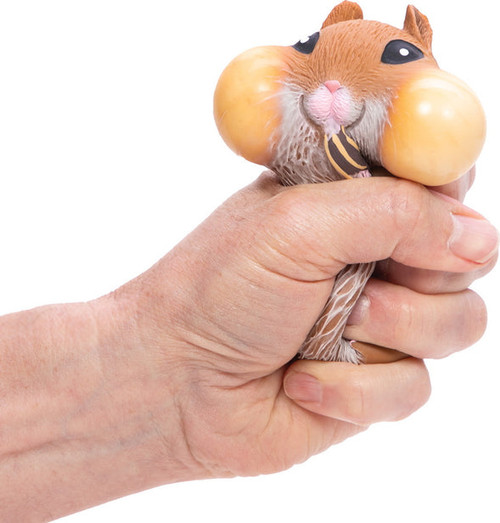 a hand squeezing the hamster to blew up its cheeks