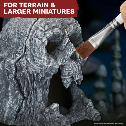 Brush adds details to a piece of miniature terrain
