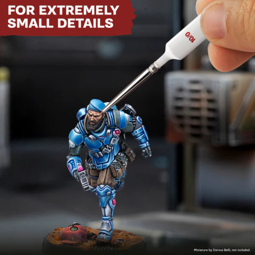 Brush paints details on a miniature