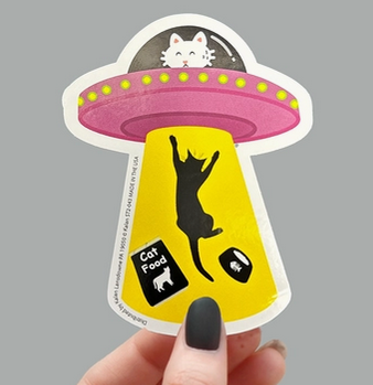 Sticker depicting a cat being pulled up into a flying saucer