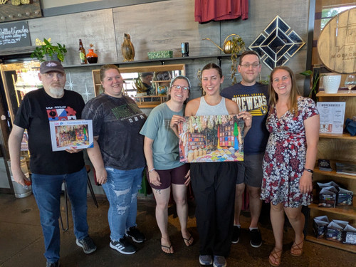 Six winners smile, one holding the completed puzzle