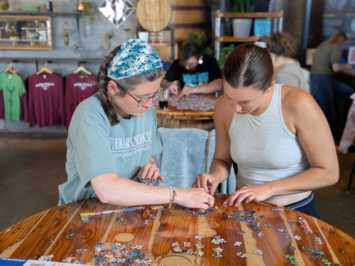 Two players work side-by-side on their puzzle