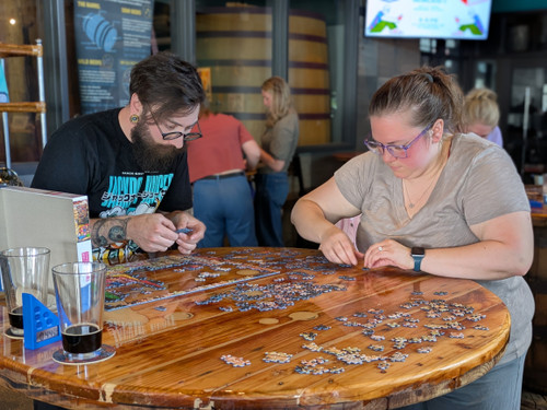 Two participants stand as their work on their puzzle
