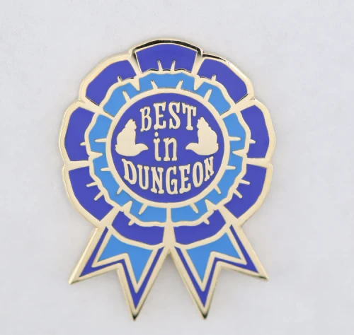 Enamel pin depicting a blue ribbon that reads "Best in Dungeon"