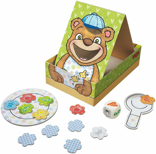 Game components including a bear, a plate, colorful food splatters, spoon, dice