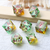 Full set of seven translucent greenish dice with pink numerals