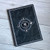 a spiraled black notebook with Colostle theme