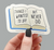 Sticker depicting an open book, its pages reading, "Things I wanted to say but never did"