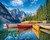 Calm Canoes with a mountain and evergreen tree backdrop