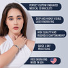 Advertisement for custom engraved medical ID bracelets featuring a young woman with long dark hair wearing a white sleeveless top. She models a silver medical ID bracelet with a black central plate on her right wrist. To the right, five dark blue text boxes highlight product features: 'PERFECT CUSTOM ENGRAVED MEDICAL ID BRACELETS,' 'DEEP AND HIGHLY VISIBLE LASER ENGRAVING,' 'HIGH QUALITY AND RIGOROUS CRAFTSMANSHIP,' 'QUICK 1 DAY PROCESSING,' and 'FREE ENGRAVING MADE IN USA,' accompanied by a heart-shaped American flag icon. The background is light blue-grey with a clean, modern design.