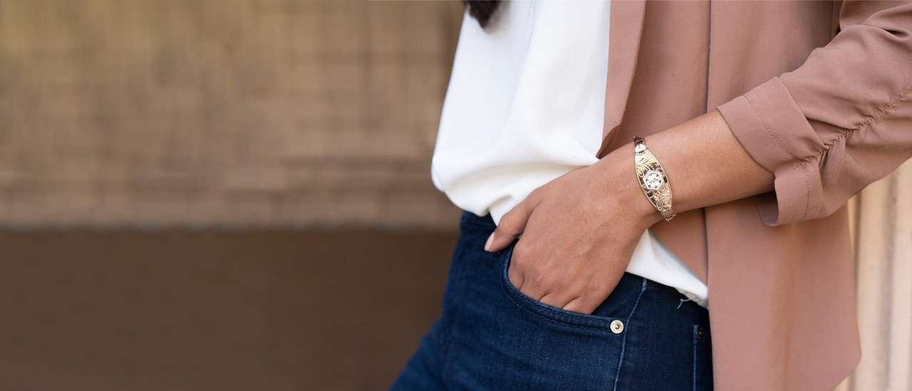 Woman wearing a rose gold Divoti medical ID bracelet, hand in her jeans pocket