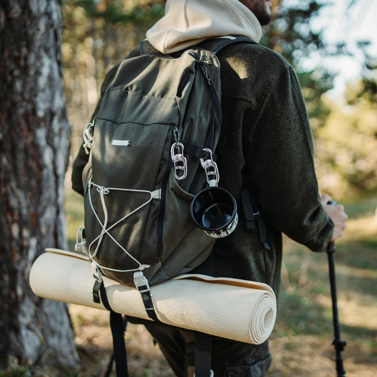 Hiker with a STEEL HAWK dual locking carabiner clipped to a backpack