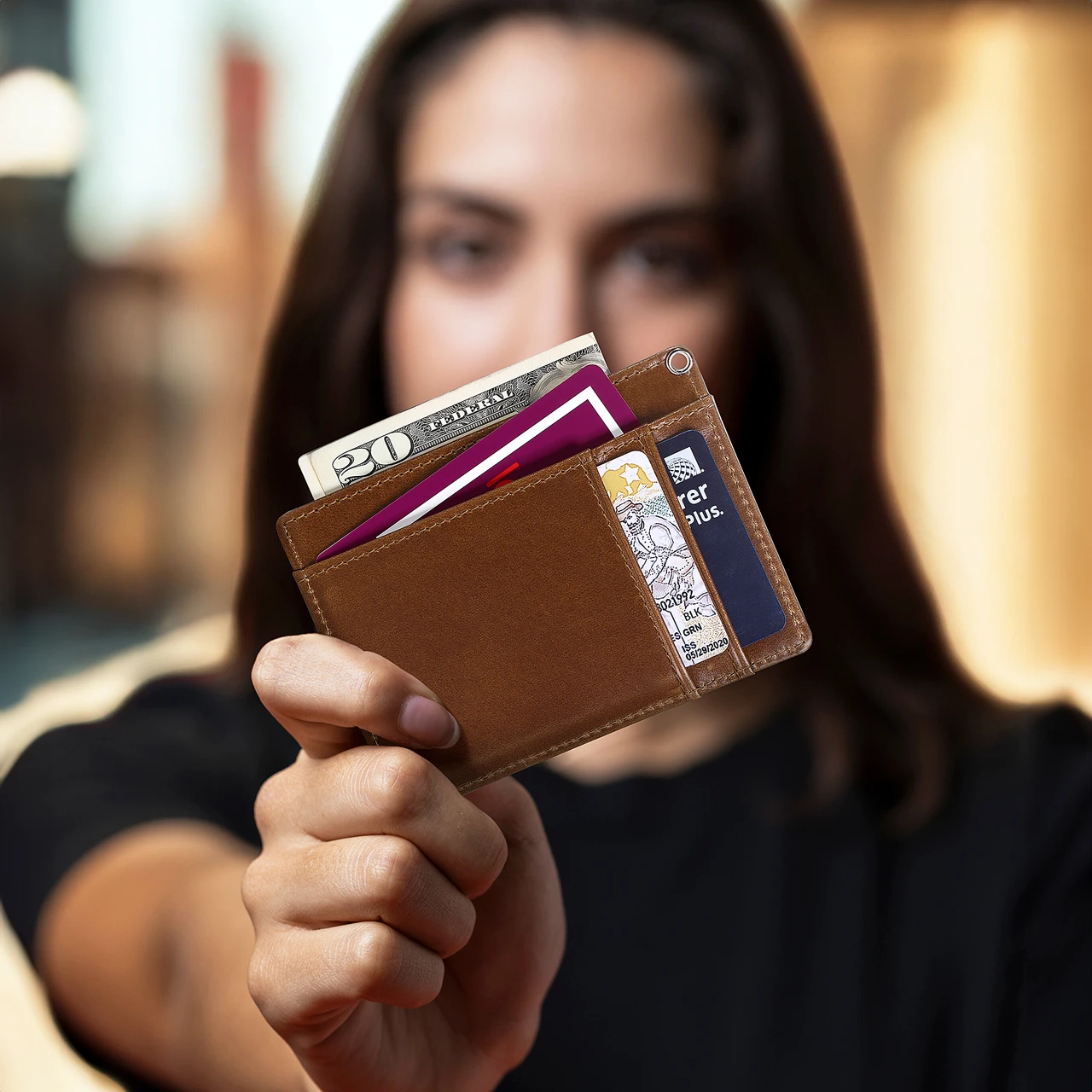 Hand holding a brown BISONDALE minimalist leather card wallet