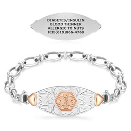 A silver medical alert bracelet with rose gold accents displayed on a white background. The bracelet features a central oval-shaped tag with a textured silver background and a rose gold hexagonal emblem in the center, showcasing the Star of Life symbol. The tag is flanked by small rose gold heart designs near the lobster clasps that connect the chain. The chain consists of polished, interlocked oval links. Above the bracelet, a flat view of the reverse side of the tag is shown, engraved with medical information: "DIABETES/INSULIN, BLOOD THINNER, ALLERGIC TO NUTS, ICE: (619) 866-4768." The design highlights both the functional and elegant aspects of the bracelet.
