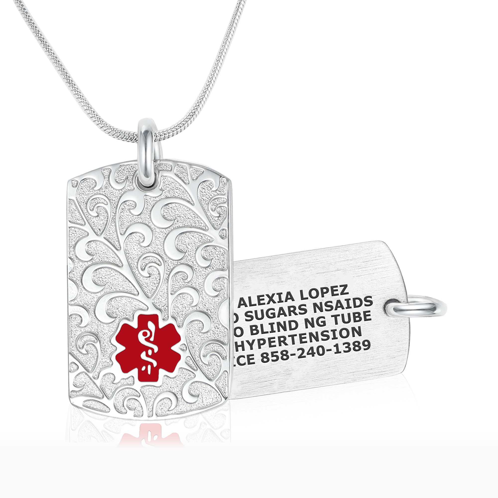Silver medical alert dog-tag pendant necklace showing both front and back sides. The front features a decorative filigree pattern with a red medical alert symbol, while the back is engraved with medical details: 'Alexia Lopez, Sugars, NSAIDs, Blind NG Tube, Hypertension, CE 858-240-1389.' Displayed on a silver snake chain against a white background.