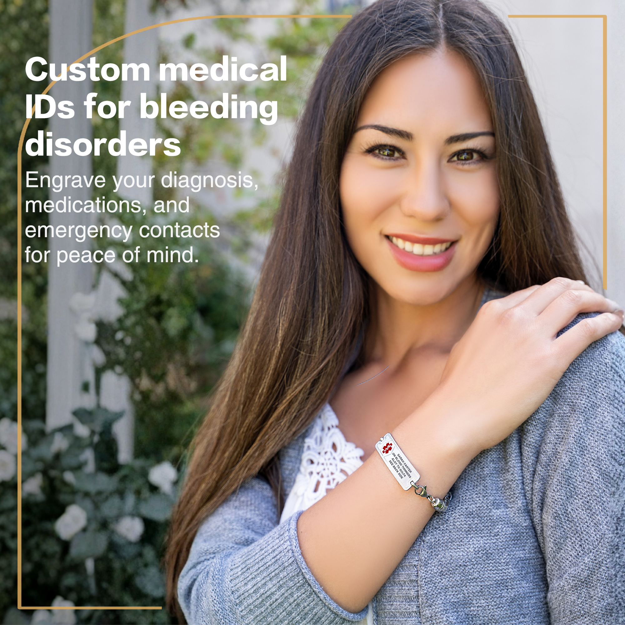 A promotional image featuring a smiling young woman with long dark hair, wearing a light grey cardigan over a white lace-detailed top. On her left wrist, she wears a silver medical alert bracelet with a red medical symbol and engraved text for medical conditions and emergency contacts. The background shows blurred greenery and white flowers, creating a serene outdoor setting. Overlaid text on the left reads, "Custom medical IDs for bleeding disorders," with smaller text below highlighting the ability to engrave diagnoses, medications, and emergency contacts for peace of mind. A thin golden-yellow line frames the image, adding a subtle design element.