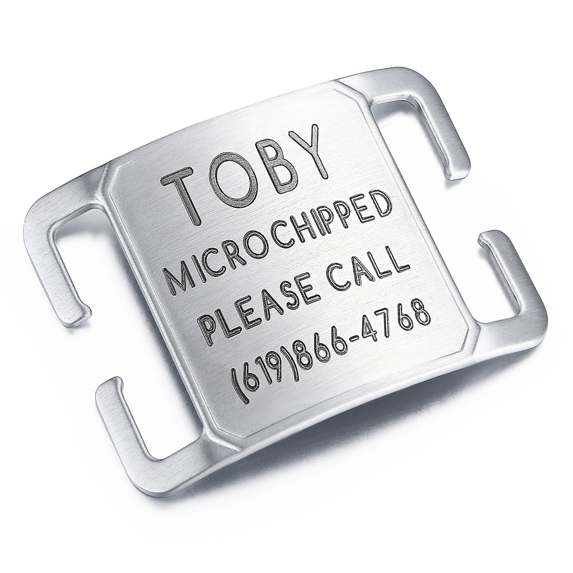 Silver brushed metal pet ID tag engraved with the name 'Toby,' microchip status, and a contact number, featuring a slide-on design for collars.