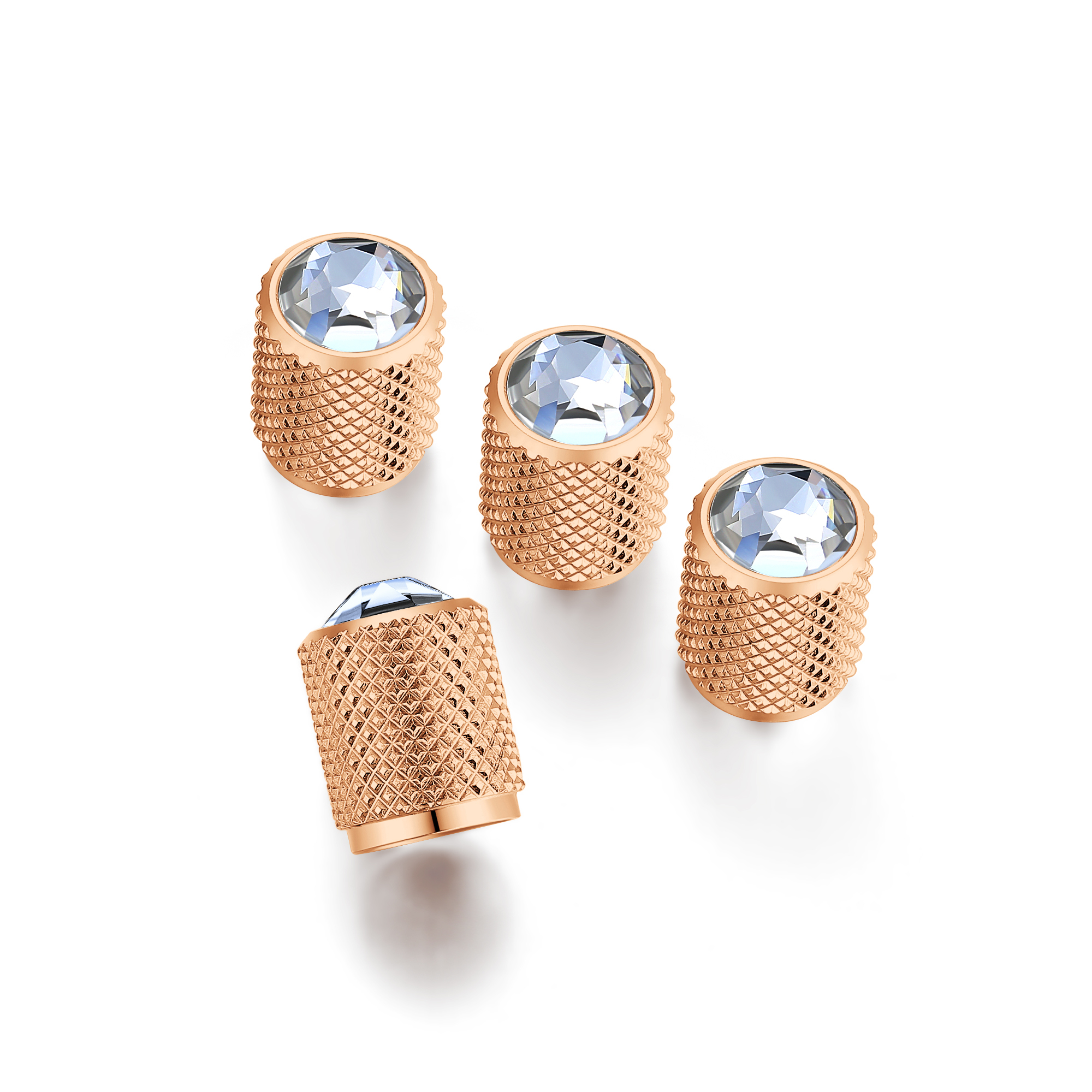 Set of four rose gold decorative caps with knurled texture and clear multifaceted gemstones, arranged elegantly on a white background.