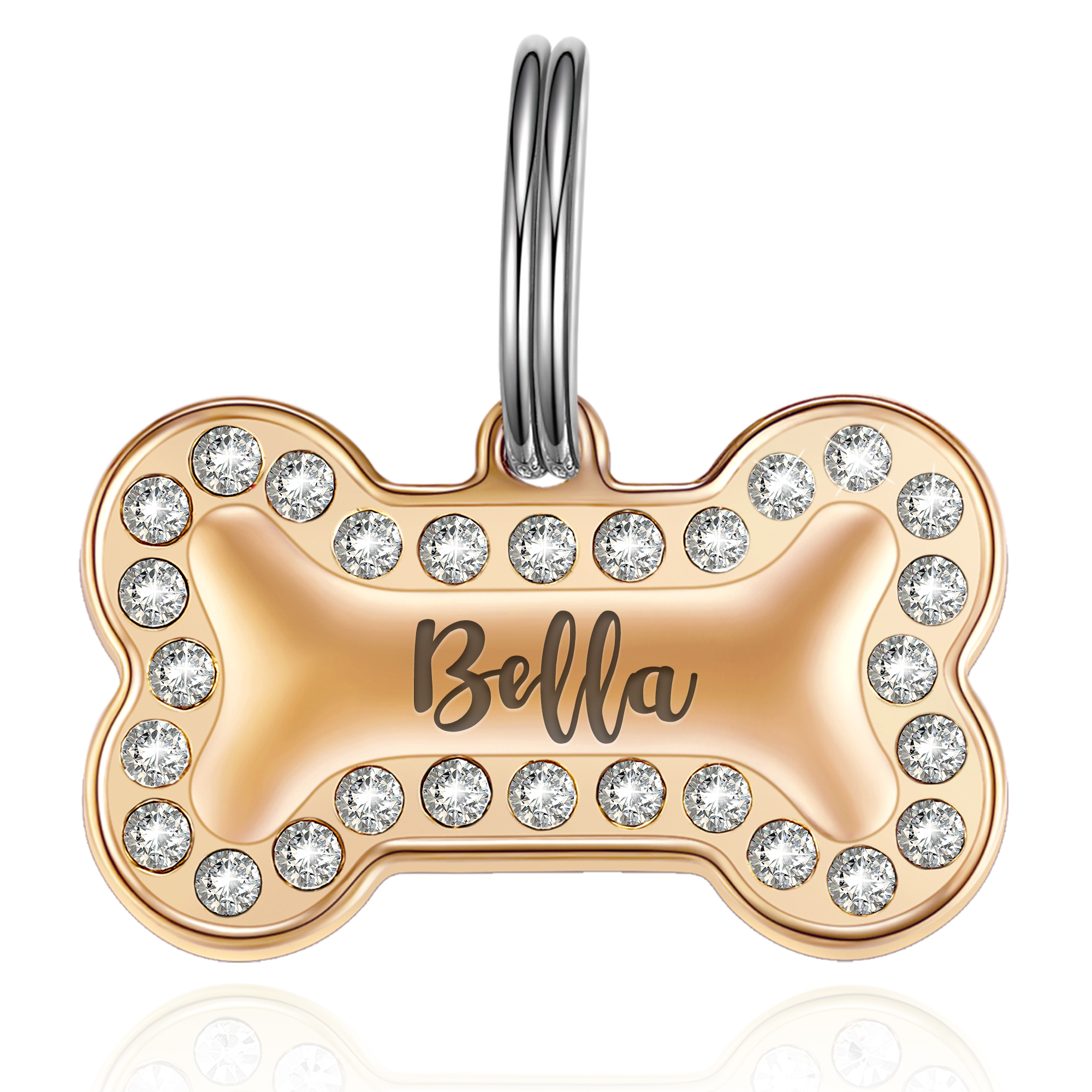 Rose gold bone-shaped pet tag adorned with clear crystals along the edges, engraved with the name 'Bella' in an elegant script font, attached to a silver split ring.