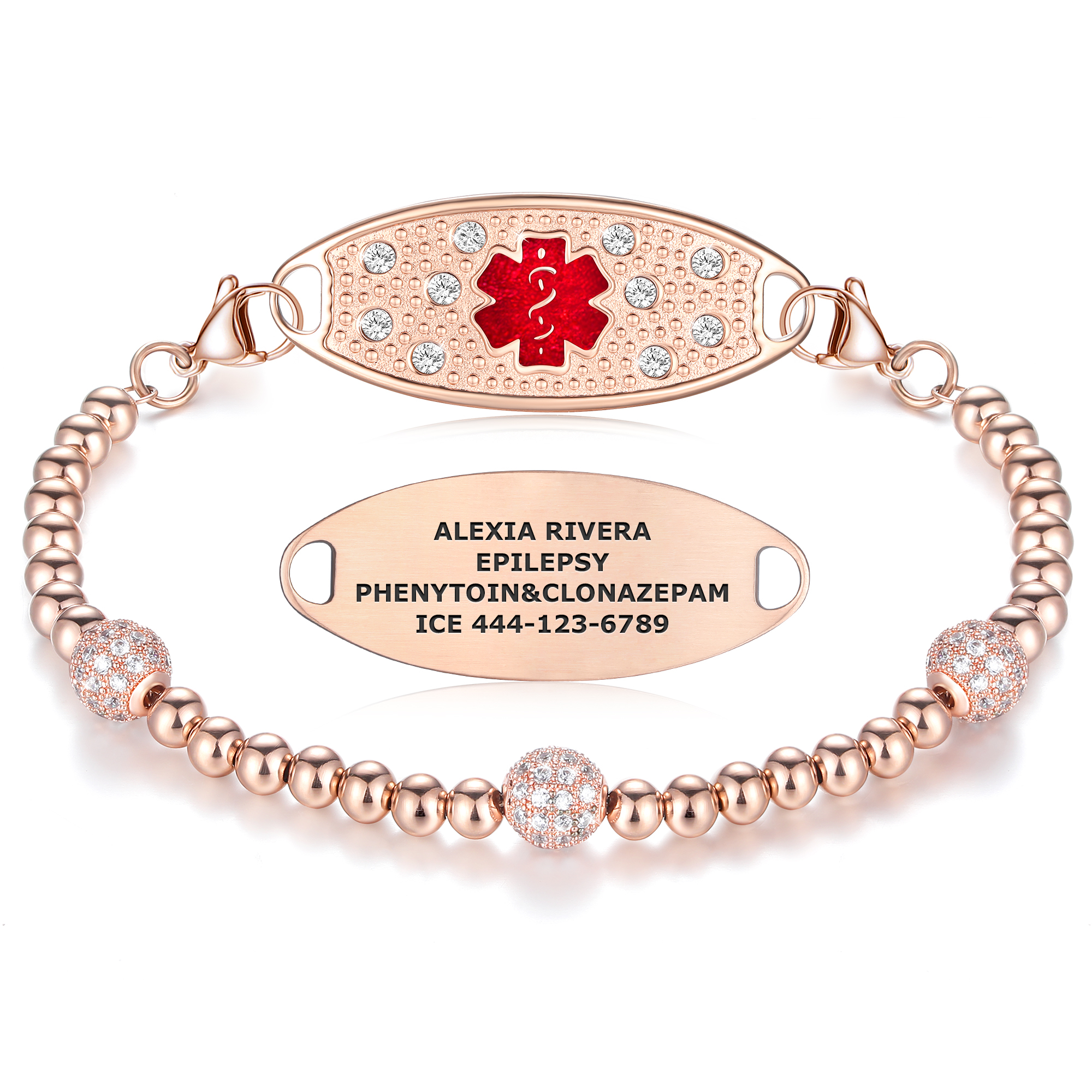 A rose gold medical alert bracelet featuring a decorative oval tag with a red Star of Life symbol surrounded by clear rhinestones and a textured cobblestone pattern. The bracelet is made of two strands of polished rose gold beads, accented with larger rhinestone-encrusted beads. A secondary oval tag, engraved with the name "Alexia Rivera," the condition "Epilepsy," medications "Phenytoin & Clonazepam," and an emergency contact number "ICE 444-123-6789," is positioned below the main tag. The bracelet is displayed against a white background with a subtle reflection.