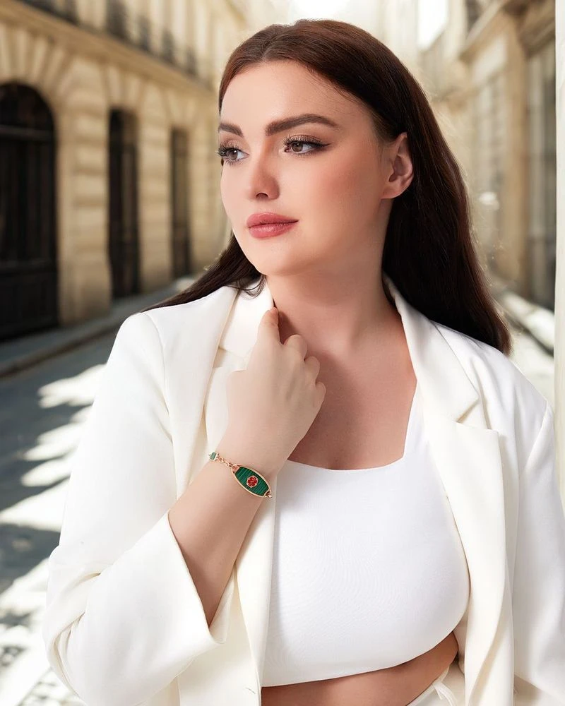 Woman in a white blazer wearing a gold medical ID bracelet