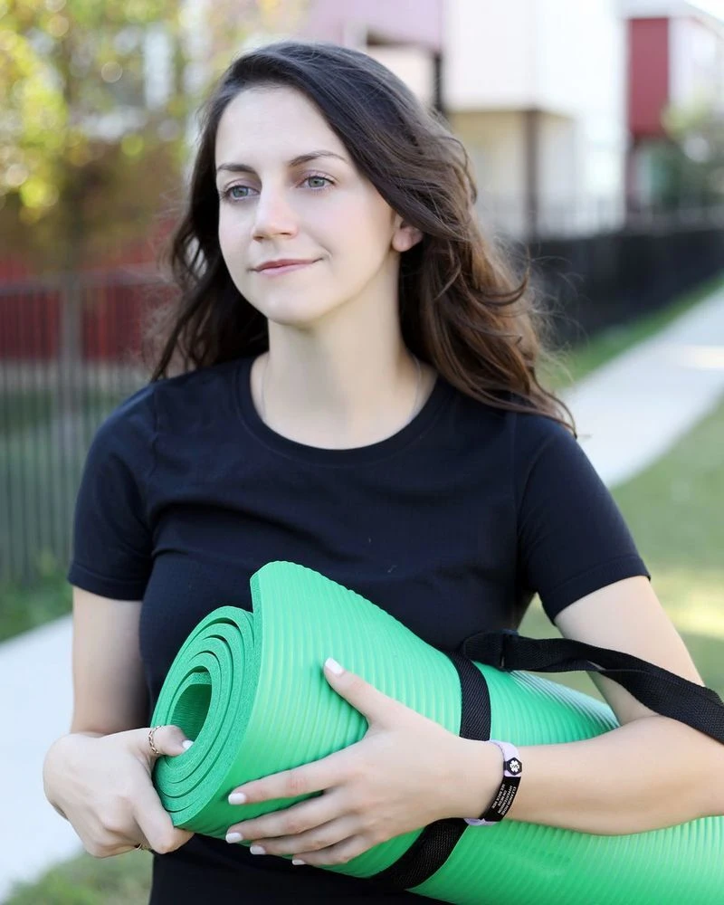 Woman with a yoga mat wearing a silicone medical ID band