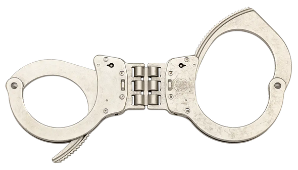 This universal Handcuff features a push pin double lock design along with the hinged design to further restrict movement in a satin nickel finish. These cuffs open 12% larger for big wrists and close 11% smaller for thin wrist for better security7. Smith & Wesson Handcuffs are fabricated from the finest quality carbon steel. They are manufactured with heat treated internal lockworks, featuring smooth ratchets for swift cuffing and double locks to prevent tampering.
