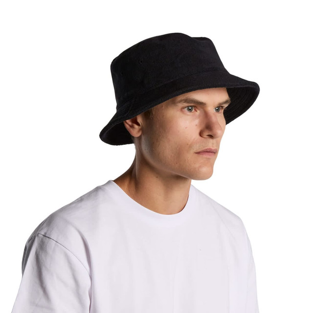 A black Terry Bucket Hat with a wide brim, displayed on a model wearing a white T-shirt.