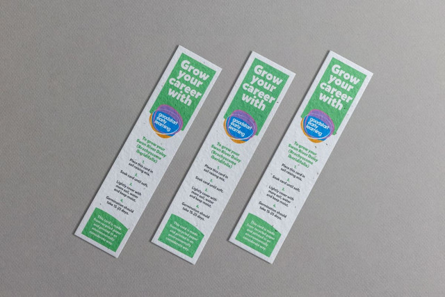 Three large seed paper bookmarks in white with green text and a circular logo, featuring a textured, eco-friendly design.