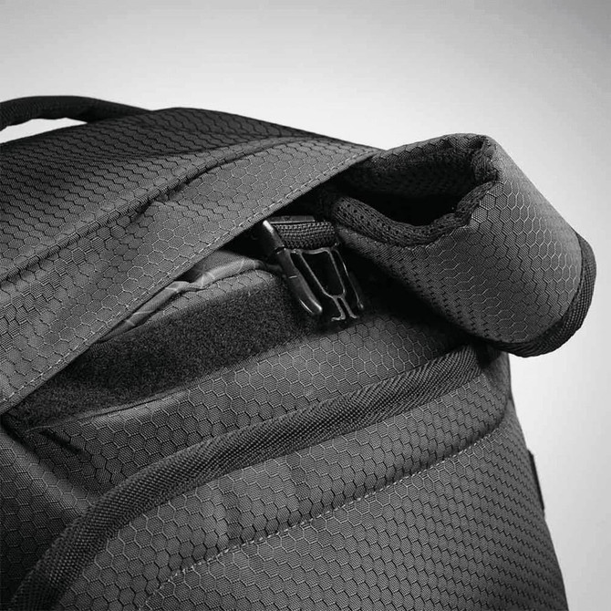 A black duffel backpack with a textured fabric and zippered opening, featuring padded shoulder straps.