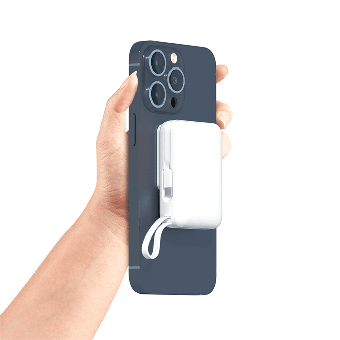 A white Infinity Magnetic Powerbank 10000 mAh attached to a dark blue smartphone, held in a hand.