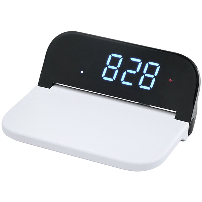 A digital clock with a black display and white base, featuring a wireless charging area.