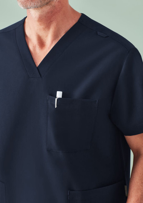 A navy unisex scrub top featuring a V-neck design and a chest pocket with a pen. It includes a logo.