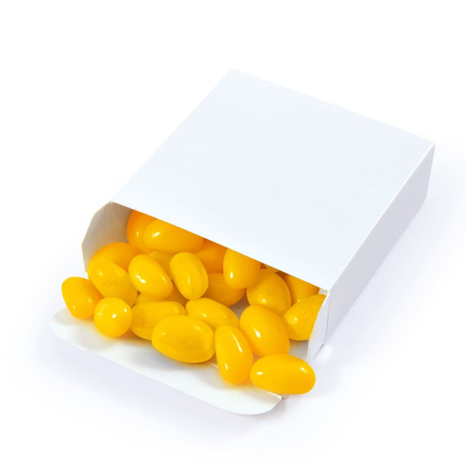 A white box filled with yellow jelly beans, some spilling out of the open packaging.
