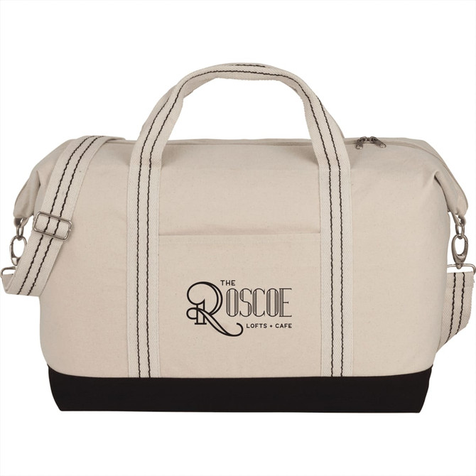 A cotton canvas duffel bag in cream with black accents, featuring handles and a detachable shoulder strap.