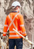 A long sleeve polo shirt in hi-vis orange with reflective stripes, worn by a worker on a construction site.