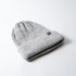 A grey knitted beanie with a folded cuff and a small logo.