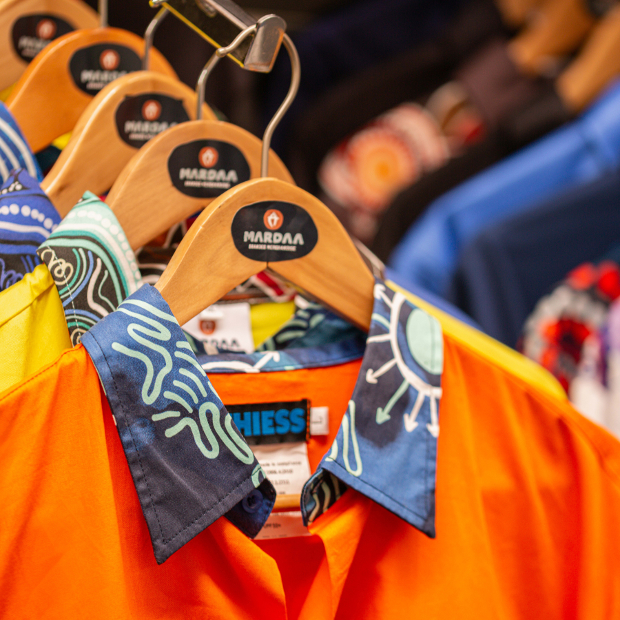 A colorful embroidered logo on the chest, featuring an abstract landscape design.