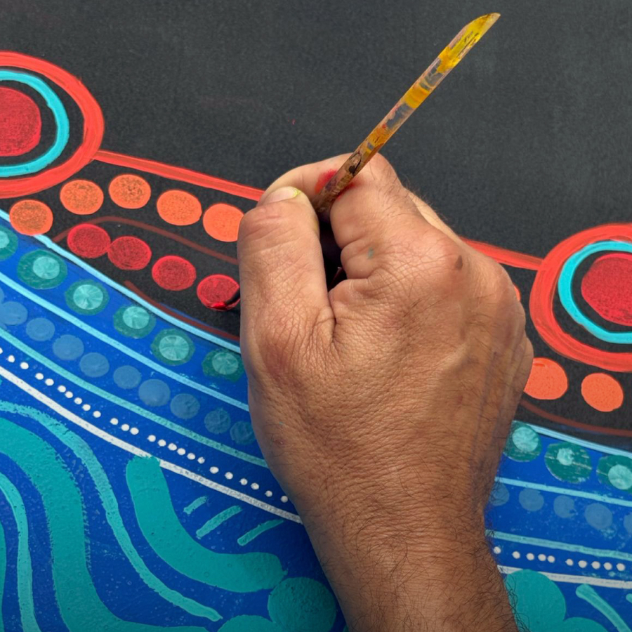 A hand delicately paints vibrant patterns on a surface