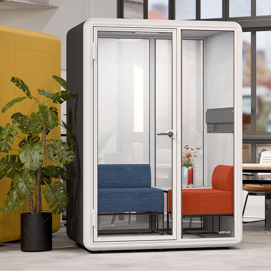 Modern office space featuring a private soundproof booth with glass doors.