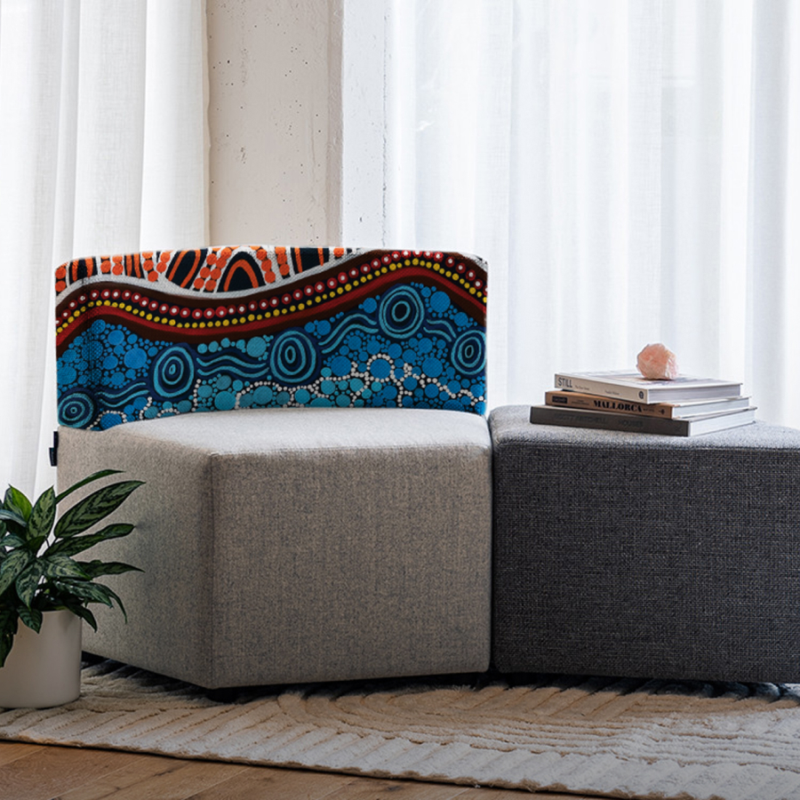 A vibrant Aboriginal-inspired ottoman with blue, red, and white dot patterns