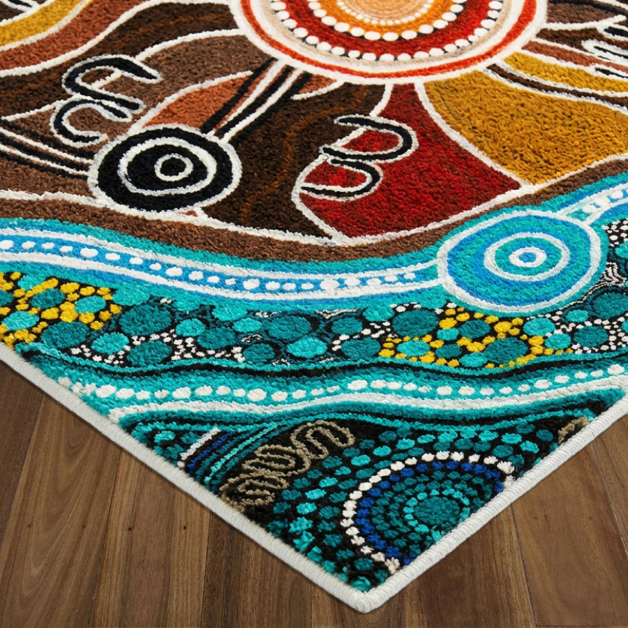 Black polo shirt with teal collar, featuring an intricate blue and teal Aboriginal-inspired pattern on the sides and sleeves