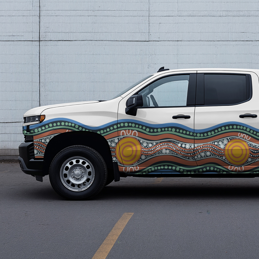 A white pickup truck with vibrant Indigenous-style art displaying wave patterns.