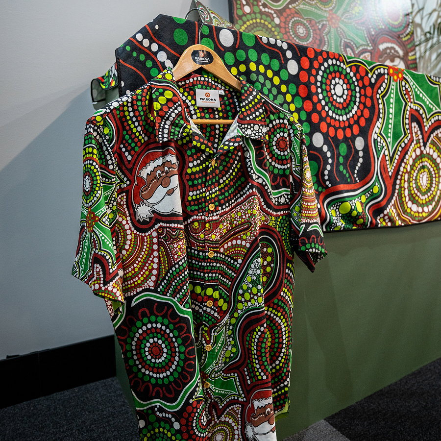 A colorful embroidered logo on the chest, featuring an abstract landscape design.