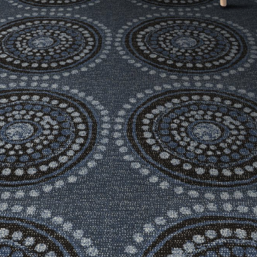 Dark blue carpet with large concentric circle patterns in lighter blue and white. The design adds a dynamic, modern feel to the space.