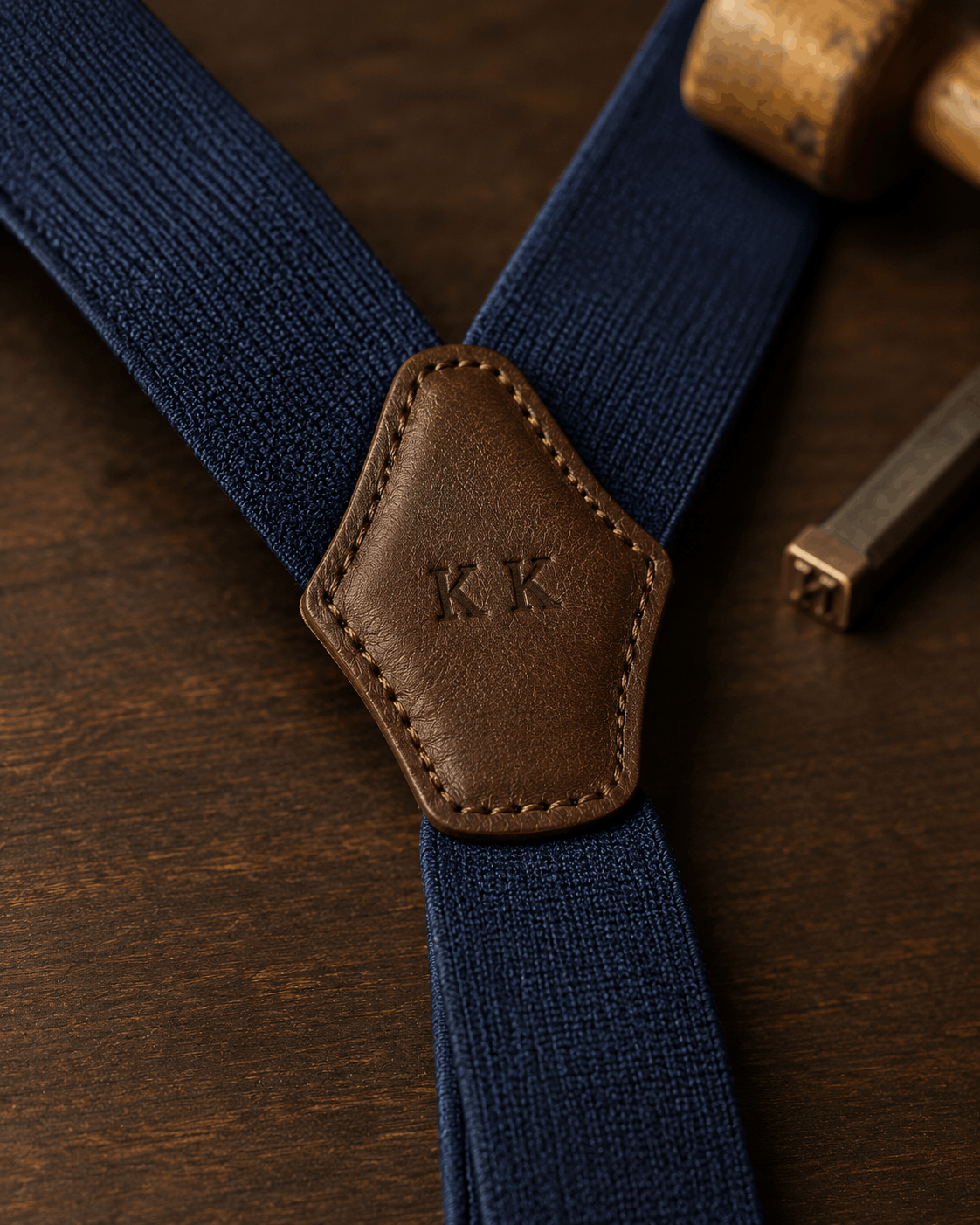 Navy suspenders with initials stamped on the leather back patch