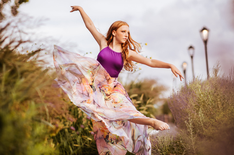 Dancer posing on a dock in front of a lake wearing FORM style  20913 in wine