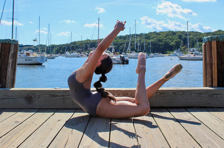 Dancer posing on a dock in front of a lake wearing FORM style  20913 in wine