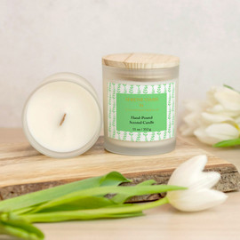 Serene Oasis Sage Botanical Vines Scented Candle Front View, Inside View, Sitting On A Piece Of Wood With Tulips Around It